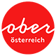 Logo Oberösterreich Tourismus: roter Kreis mit weißem upperaustria Schriftzug